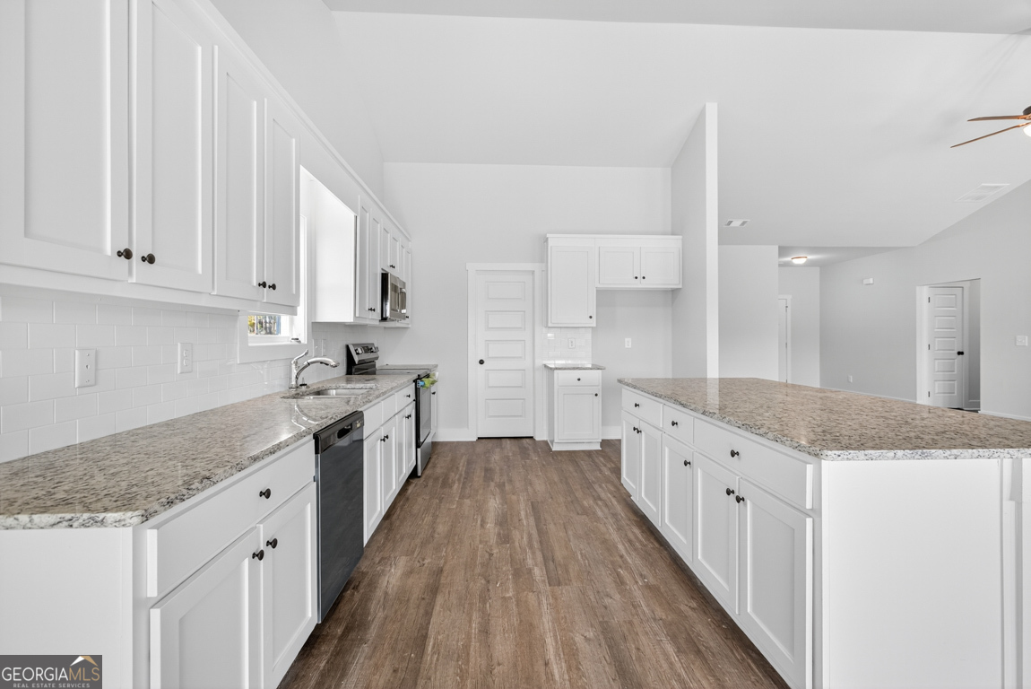 2577 Bethany Bowersville Road, Unit 7 Canon, GA 30520 - Photo 14 of 45 a large kitchen with granite countertop a sink a stove top oven a counter space and cabinets