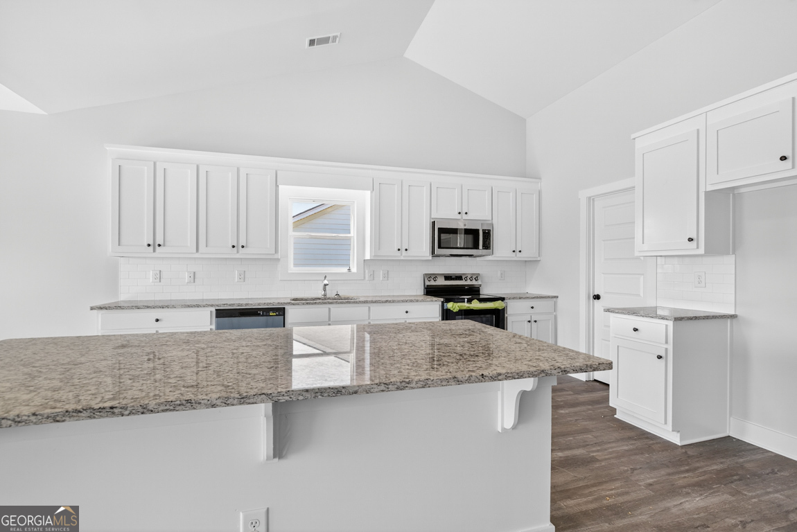 2577 Bethany Bowersville Road, Unit 7 Canon, GA 30520 - Photo 18 of 45 a large kitchen with granite countertop a stove a sink a refrigerator a white cabinets and wooden floor