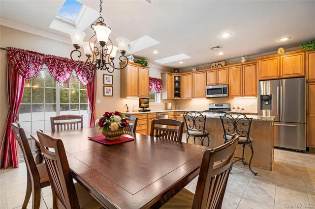 a kitchen with a dining table chairs stainless steel appliances and cabinets