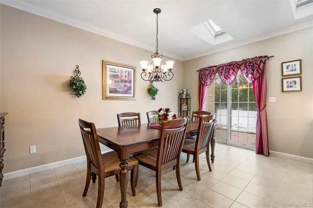 a dining room with furniture a chandelier and window