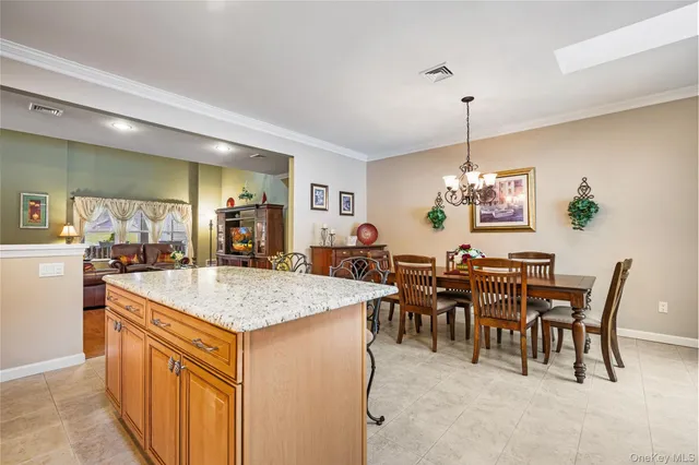 a view of a dining room and livingroom with furniture wooden floor a chandelier