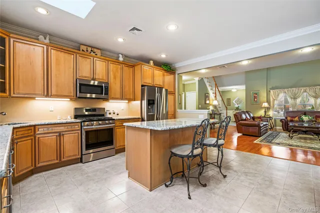 a kitchen with stainless steel appliances granite countertop a stove top oven a sink a dining table and chairs