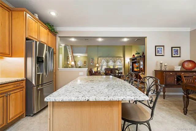 a kitchen with stainless steel appliances granite countertop table chairs and a refrigerator