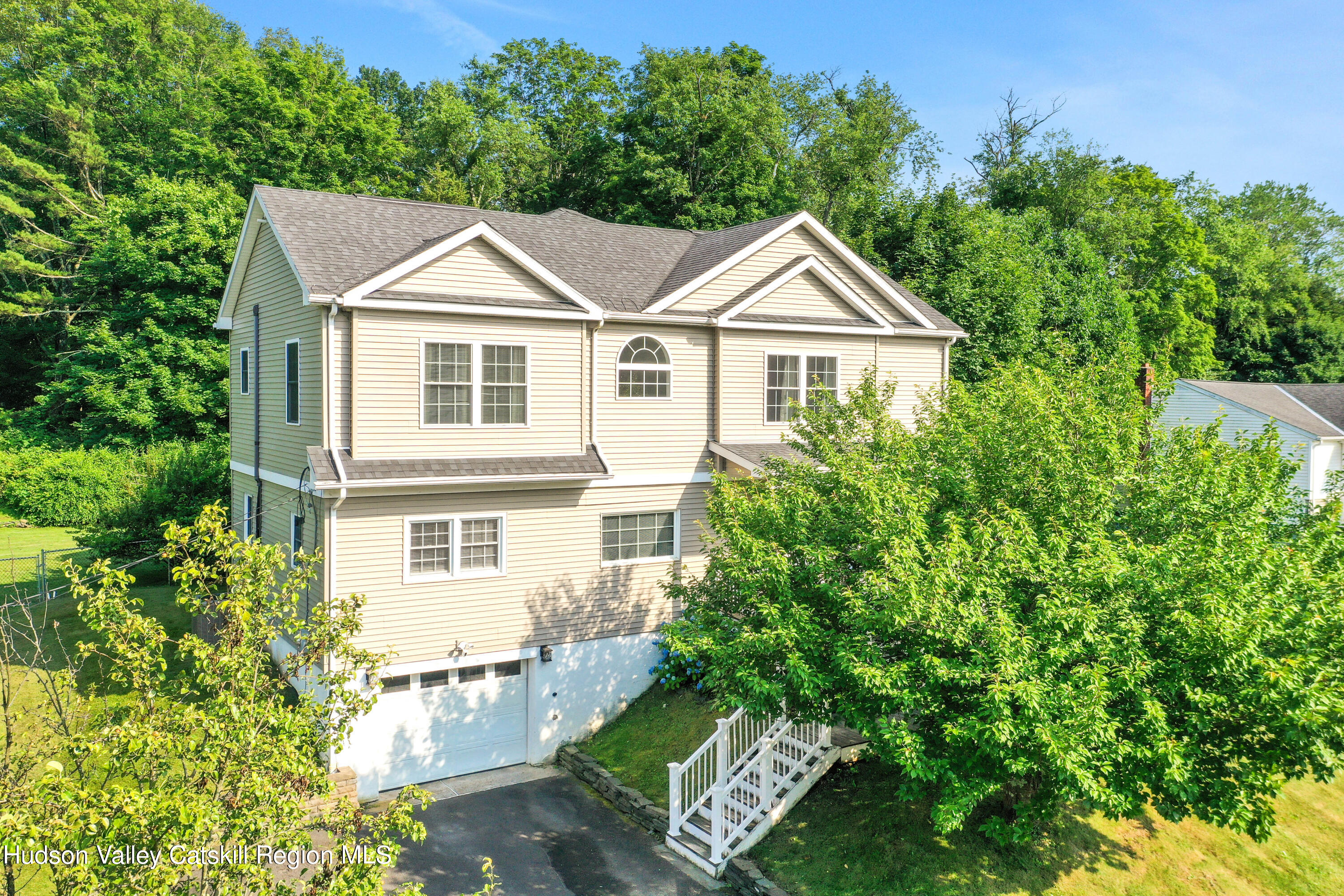 187 Russell Road Hurley, NY 12443 - Photo 2 of 33 a view of a white house next to a yard with plants and trees