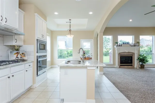 a kitchen with kitchen island granite countertop a stove a sink and a refrigerator