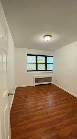 a view of a room with wooden floor and window