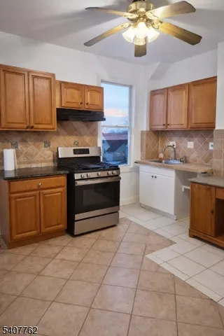 a kitchen with stainless steel appliances granite countertop a stove a sink and a microwave