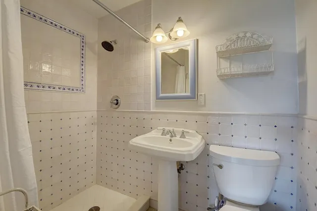 a bathroom with a sink a toilet and a mirror