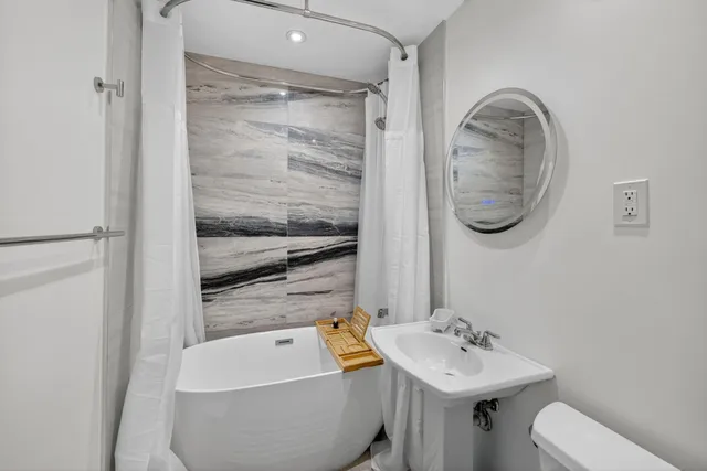 a view of pool with lawn chairs and plants