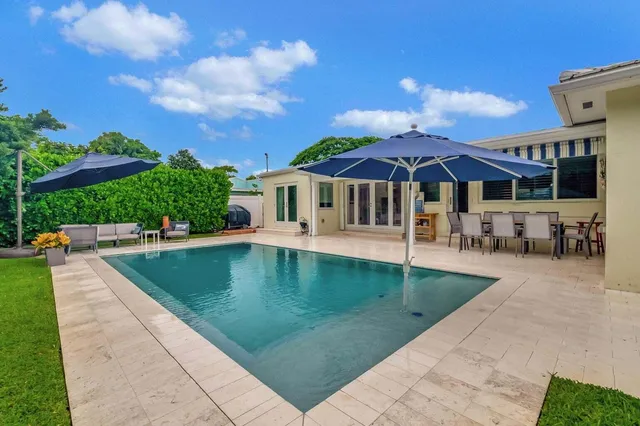 an aerial view of residential houses with outdoor space and trees