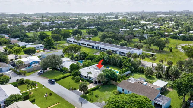 an aerial view of a house with a yard and large tree