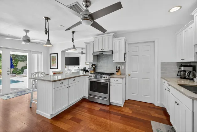a kitchen with stainless steel appliances granite countertop a stove and cabinets