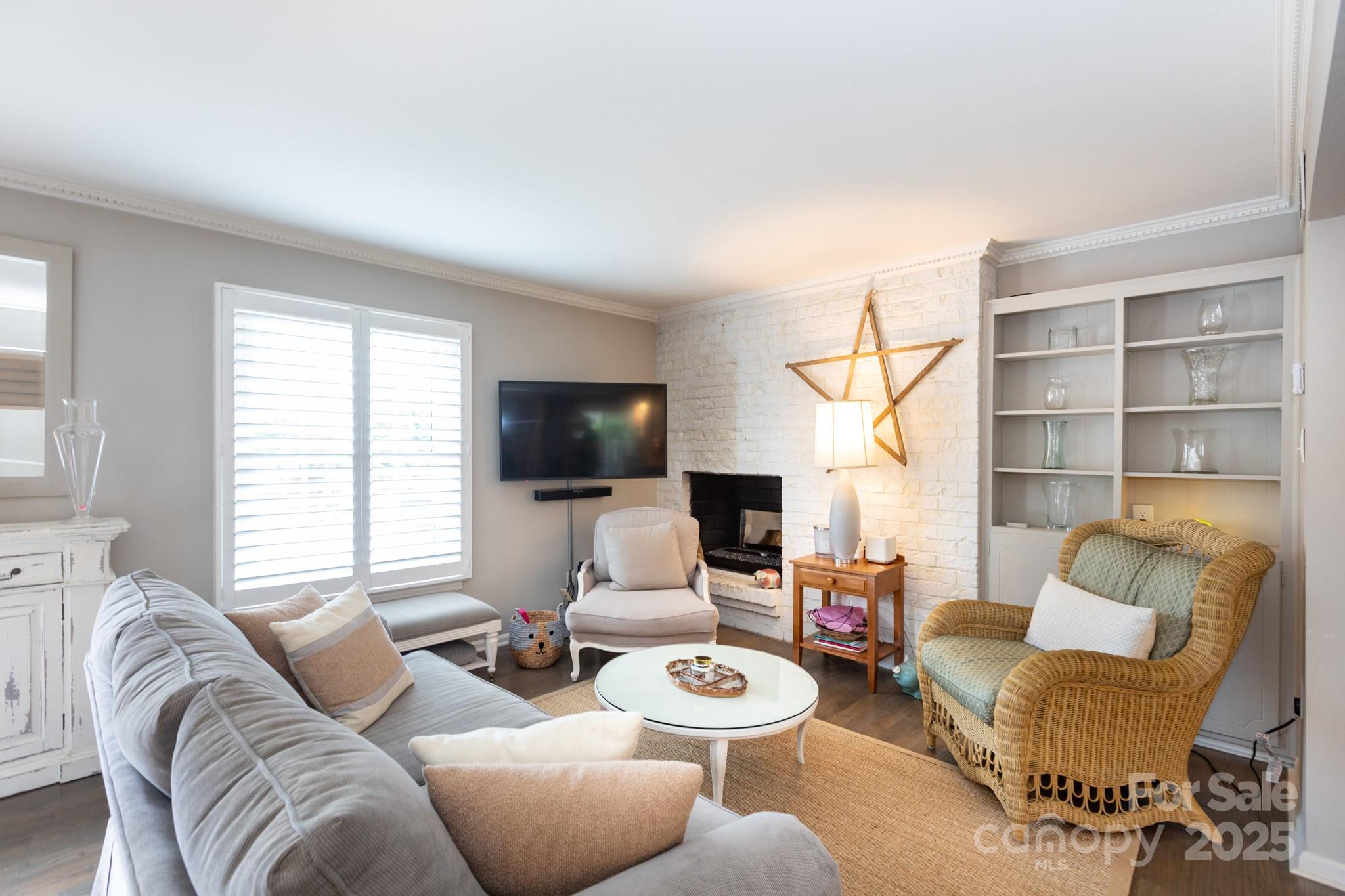 a living room with furniture a flat screen tv and a large window