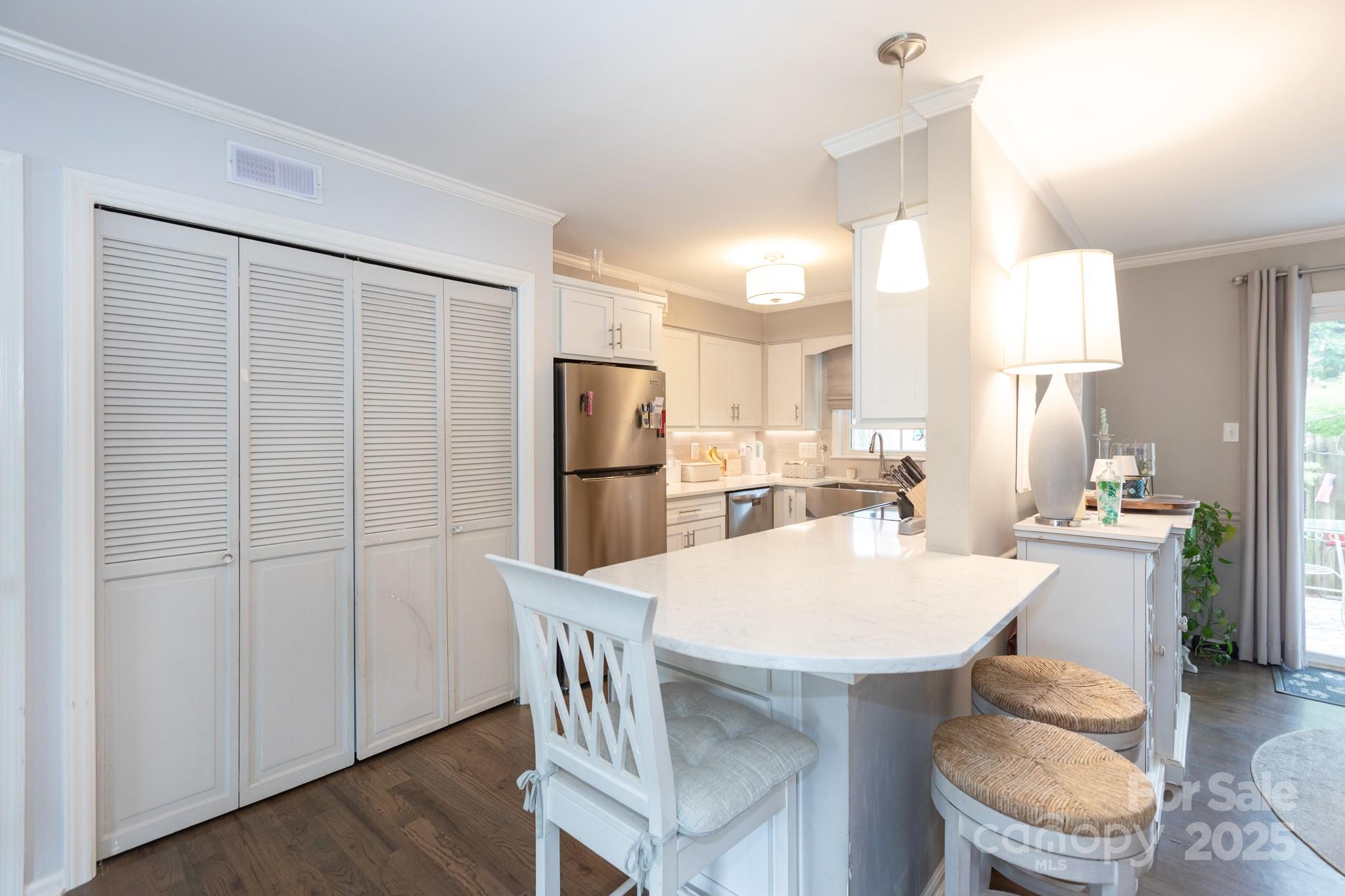 2229 Rexford Road, Unit E Charlotte, NC 28211 - Photo 16 of 28 a kitchen with stainless steel appliances refrigerator dining table and chairs