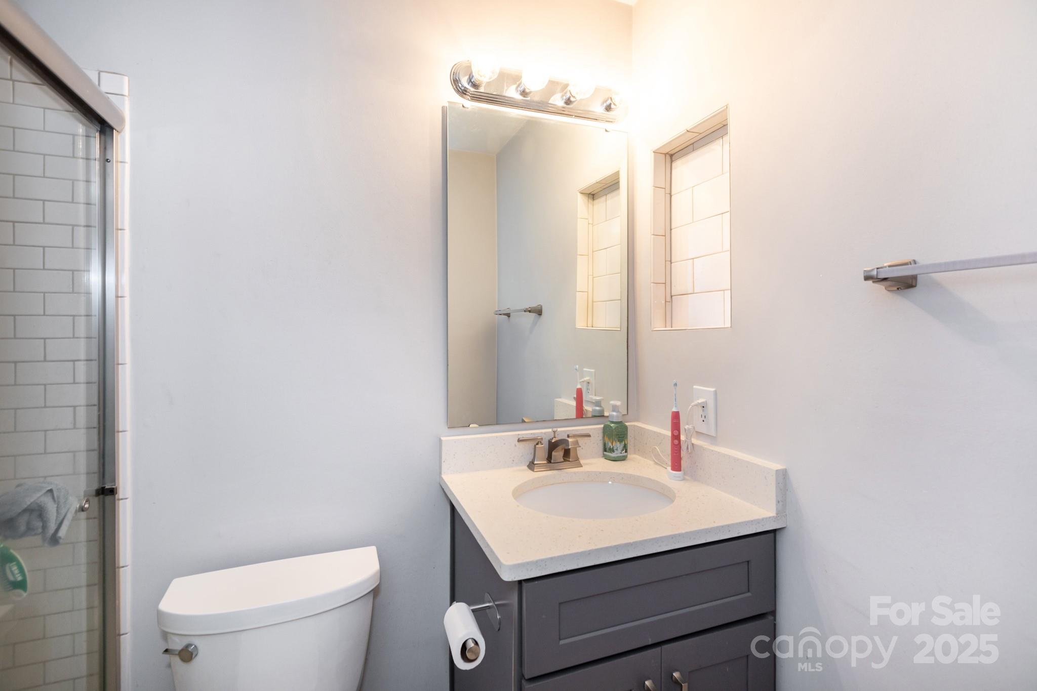 2229 Rexford Road, Unit E Charlotte, NC 28211 - Photo 24 of 28 a bathroom with a sink toilet and mirror