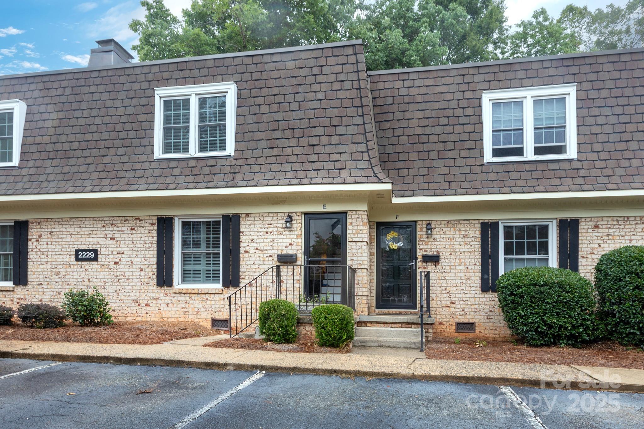 2229 Rexford Road, Unit E Charlotte, NC 28211 - Photo 3 of 28 a view of a brick house with a yard and large tree
