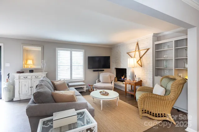 a living room with furniture a flat screen tv and a window