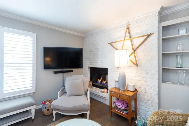 a living room with furniture a flat screen tv and a window