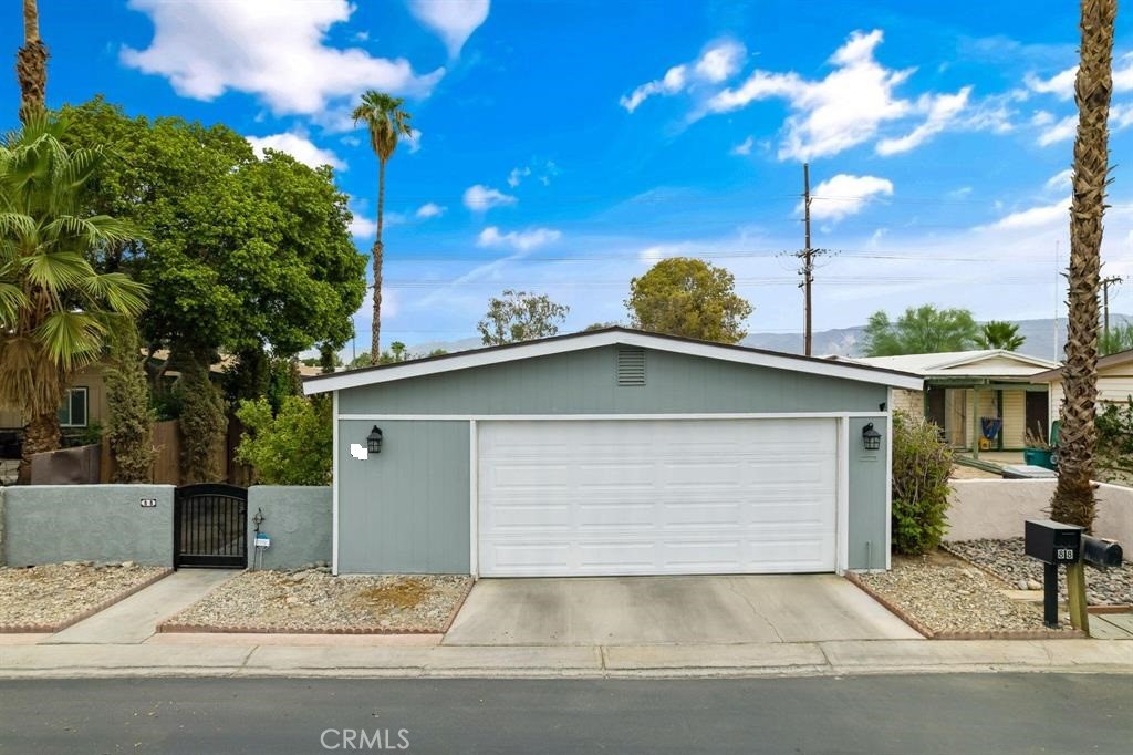 81641 Ave 48, Unit 88 Indio, CA 92201 - Photo 2 of 17 a front view of a house with a yard and garage
