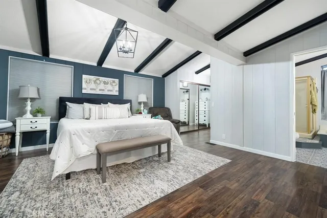 a bed sitting in a spacious bedroom next to a window