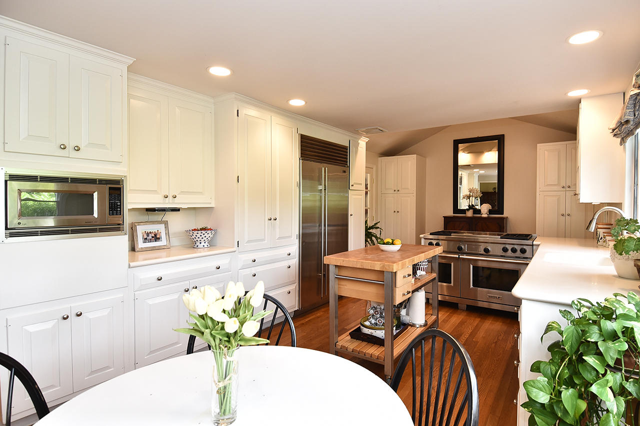 22 Country Club Road New Canaan, CT 06840 - Photo 14 of 47 a kitchen with stainless steel appliances kitchen island granite countertop a stove a sink a microwave a dining table and chairs