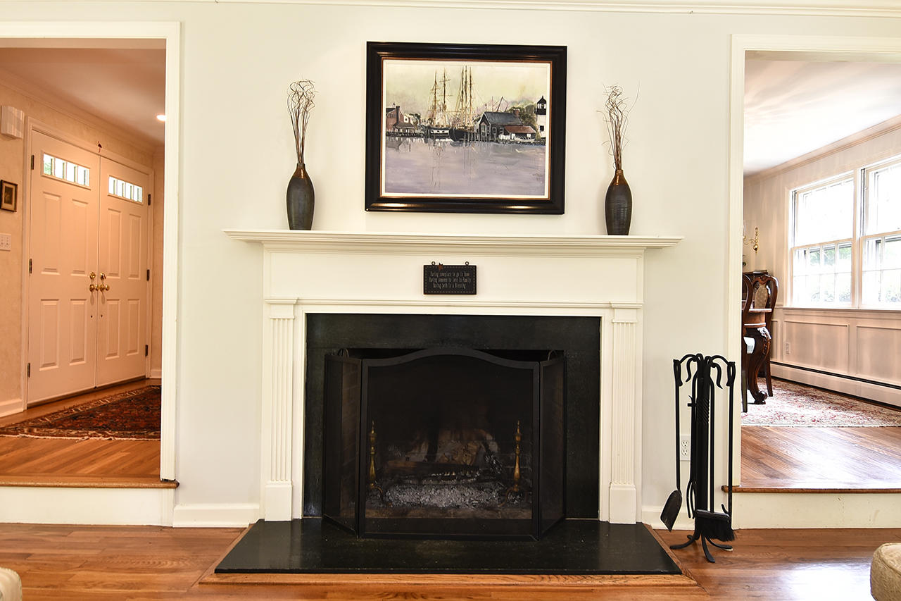 22 Country Club Road New Canaan, CT 06840 - Photo 5 of 47 a living room with a fireplace and a painting on the wall