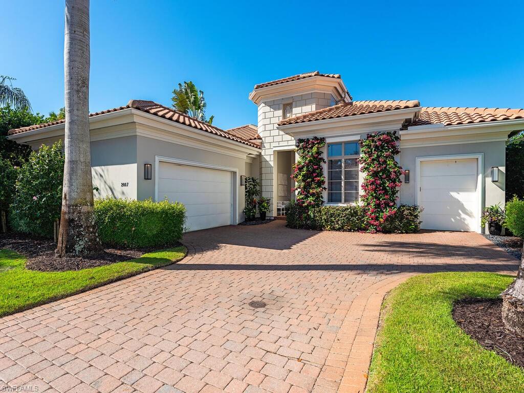 a front view of a house with a yard and potted plants
