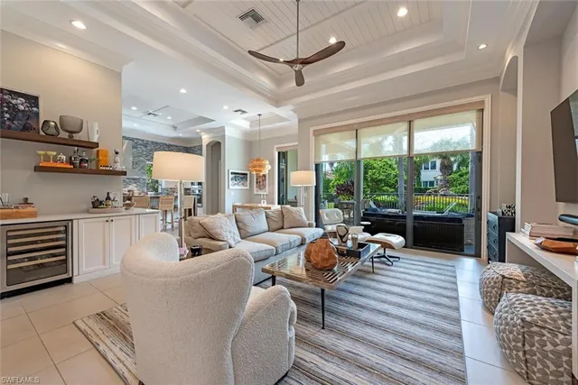 a living room with furniture large windows and wooden floor