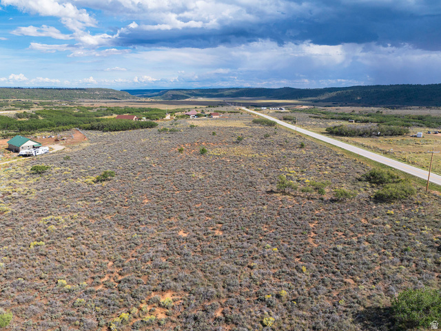 14 East Spring Draw Drive, Unit 13 La Sal, UT 84530 - Photo 4 of 17 Expansive rural landscape featuring a paved road, scattered structures, and distant natural terrain