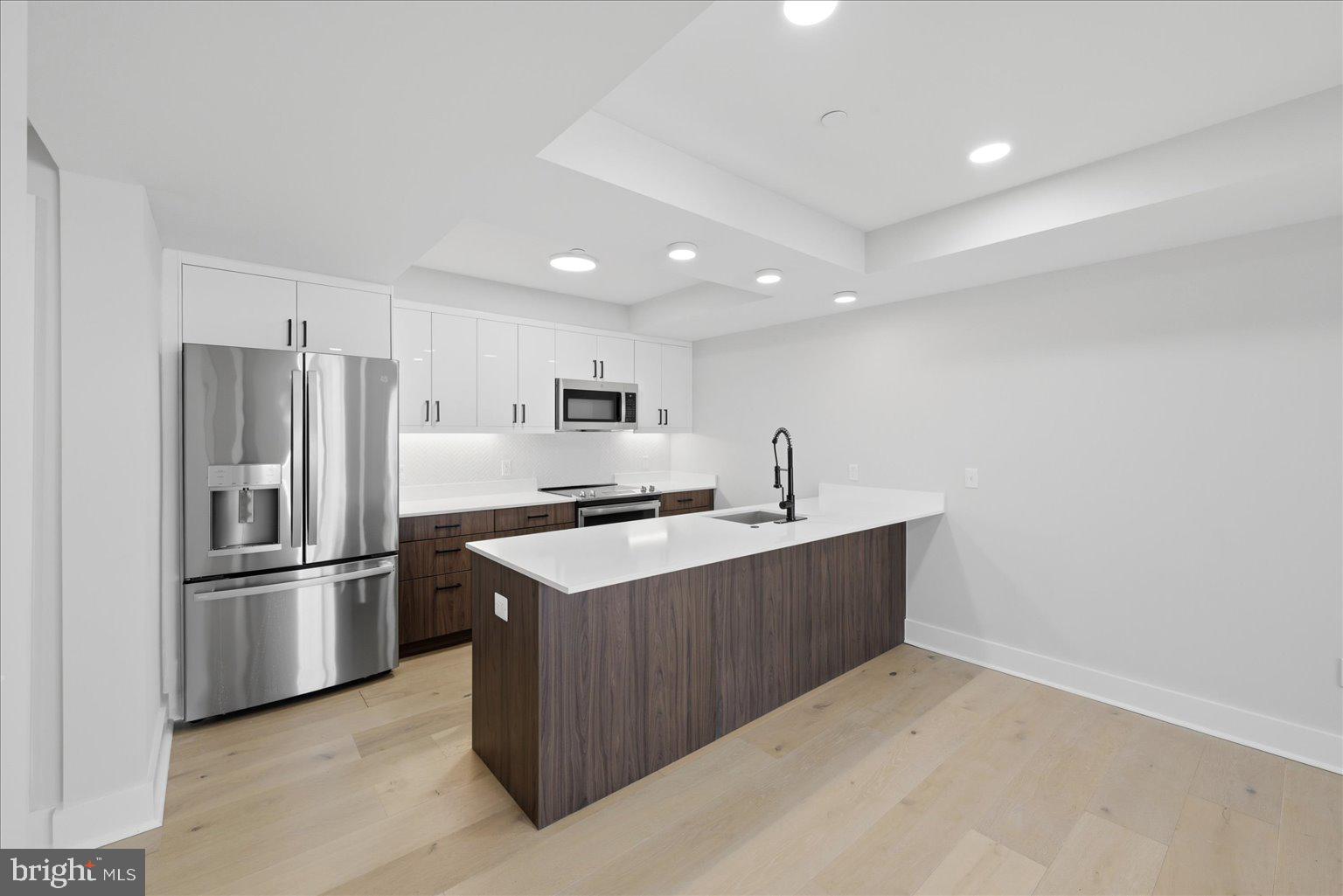 919 12th Street Northeast, Unit 303 Washington, DC 20002 - Photo 3 of 22 a large kitchen with stainless steel appliances a sink and refrigerator