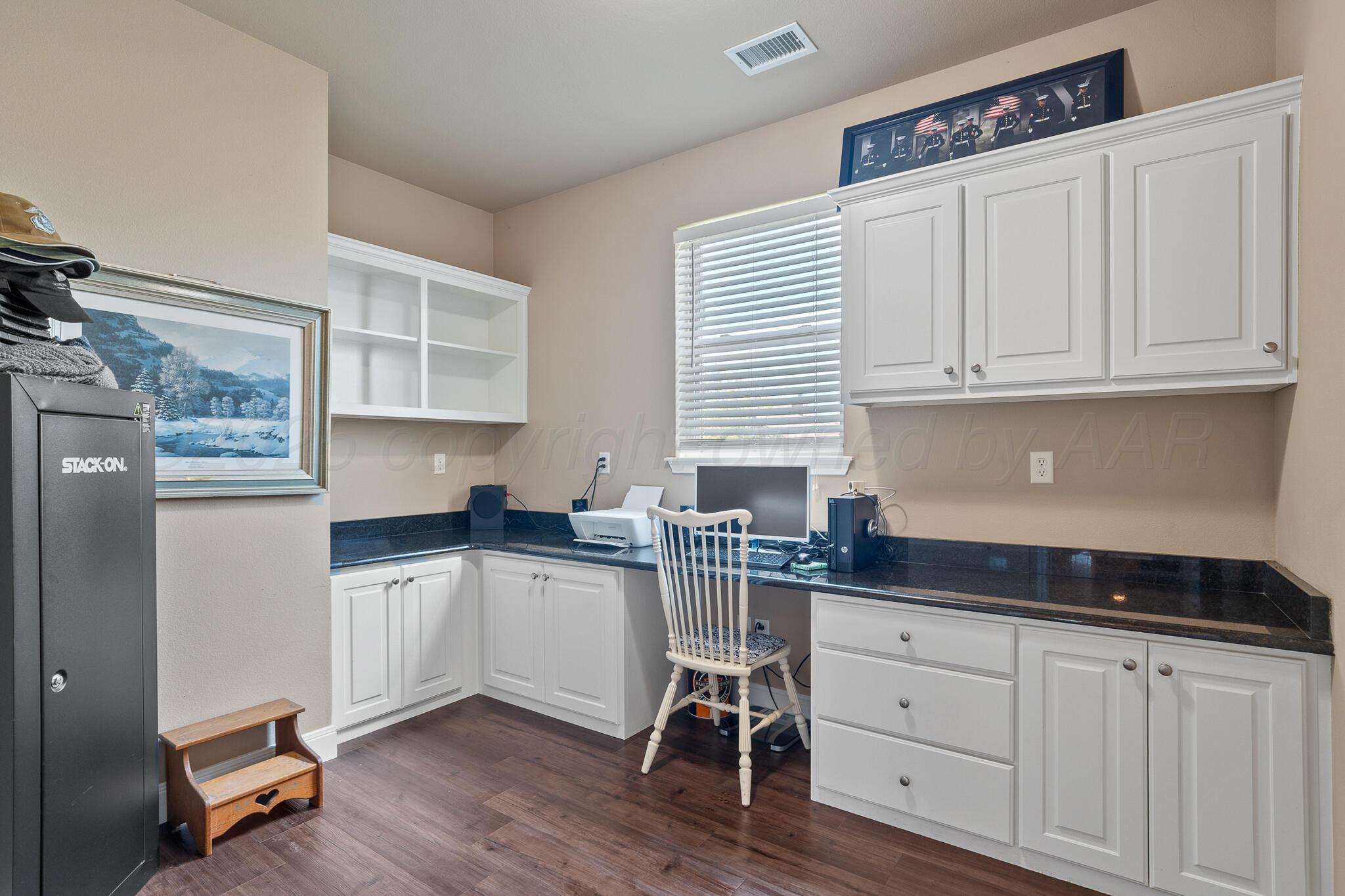 7116 Sinclair Street Amarillo, TX 79119 - Photo 11 of 23 a kitchen with granite countertop a stove a sink and white cabinets