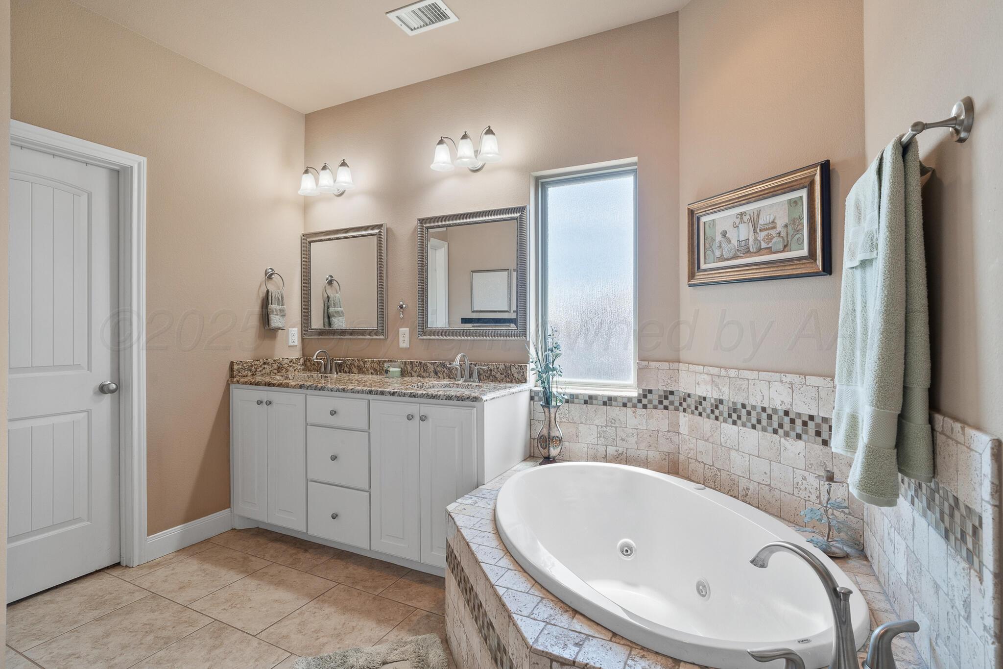 7116 Sinclair Street Amarillo, TX 79119 - Photo 14 of 23 a bathroom with a tub sink and mirror