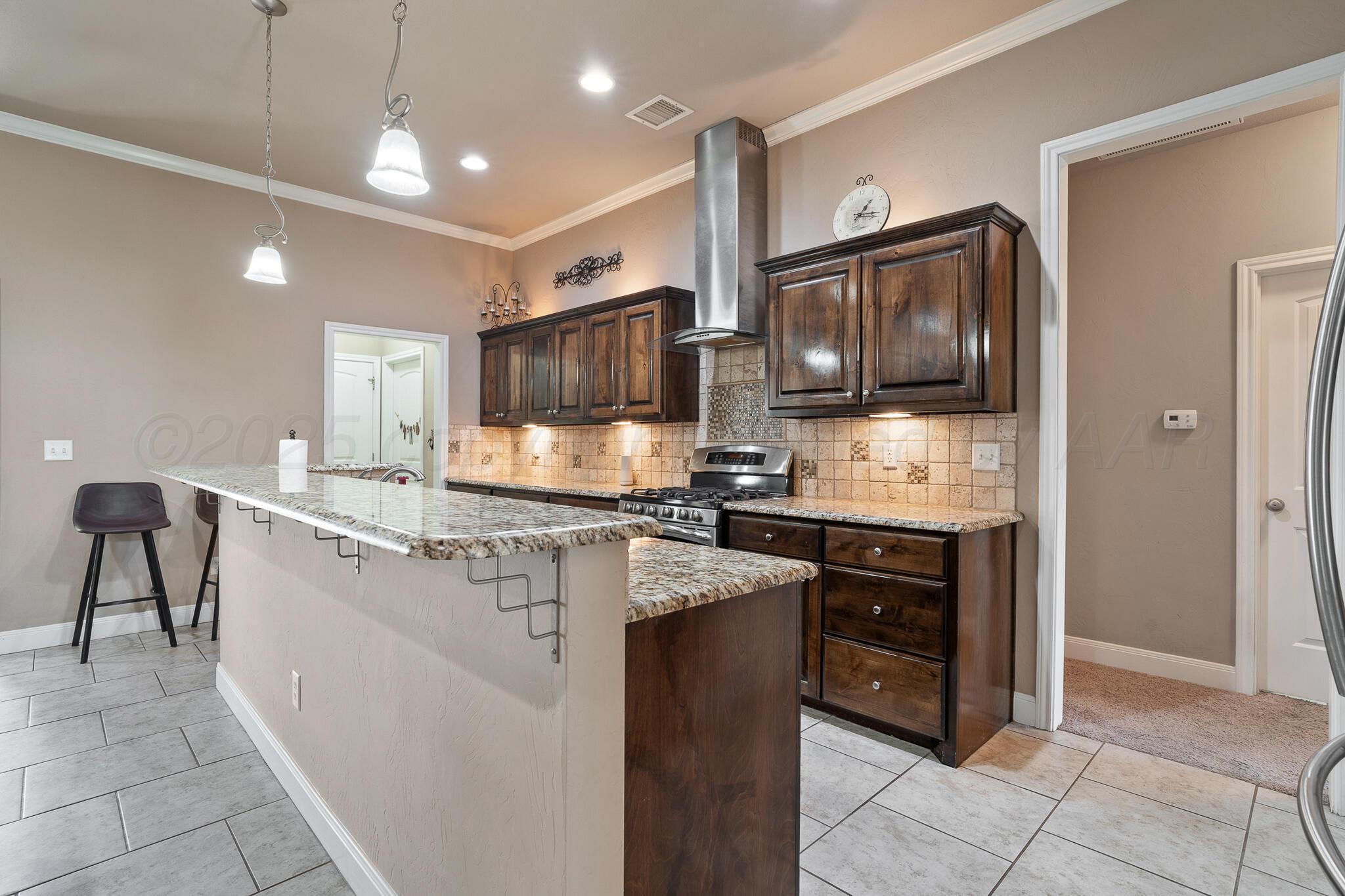 7116 Sinclair Street Amarillo, TX 79119 - Photo 5 of 23 a kitchen with stainless steel appliances granite countertop a refrigerator and a stove top oven