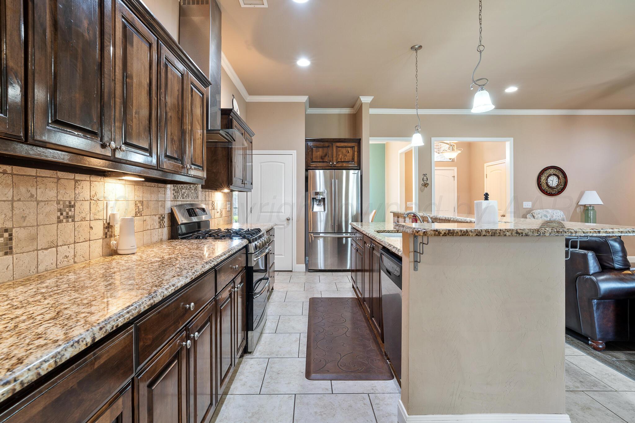 7116 Sinclair Street Amarillo, TX 79119 - Photo 7 of 23 a kitchen with stainless steel appliances granite countertop a sink a stove and a wooden floors