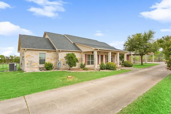 a front view of a house with a yard and trees