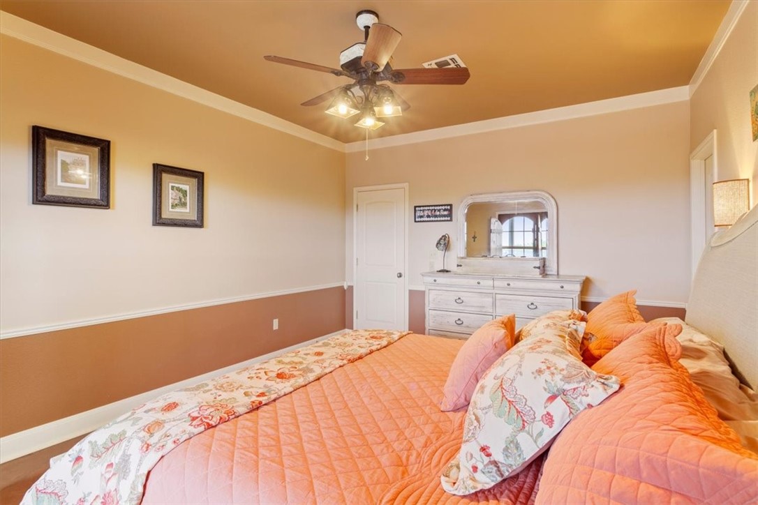 551 Bottoms East Road Temple, TX 76501 - Photo 21 of 44 a bedroom with a large bed and a chandelier
