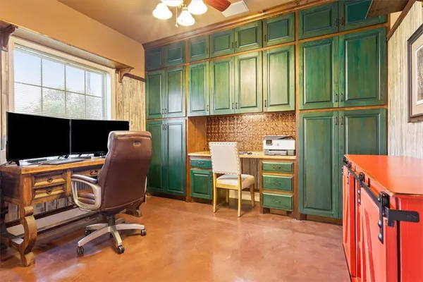 a view of a workspace with furniture and a window