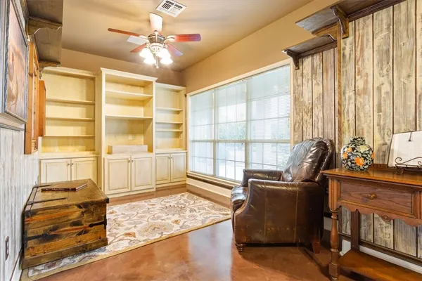 a view of a workspace with furniture and a window