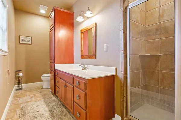 a bathroom with a sink a toilet and shower