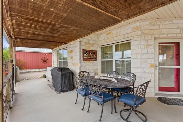 a view of a tables and chairs in back yard of the house