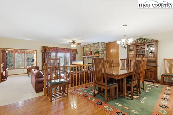 a dining room with furniture a chandelier and wooden floor
