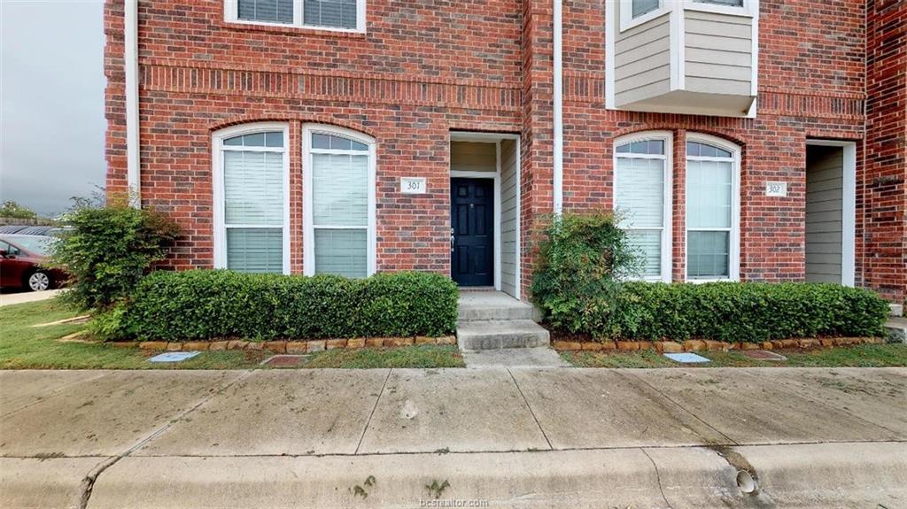 front view of a brick house with a small yard