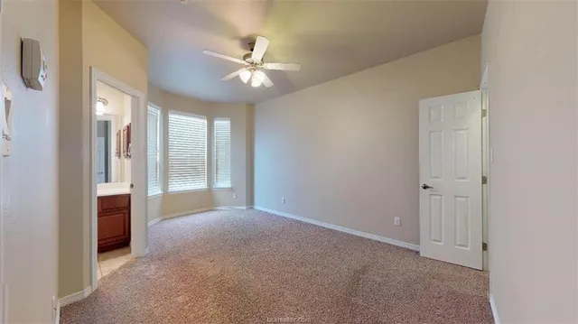 a view of a big room with chandelier fan and windows