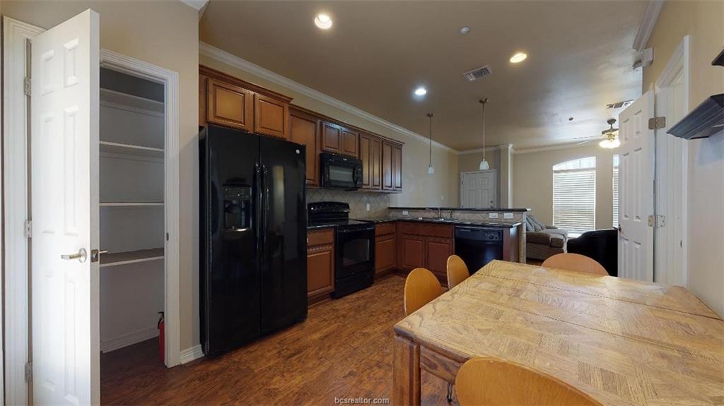 1198 Jones-Butler Road, Unit 2607 College Station, TX 77840 - Photo 6 of 20 a kitchen with stainless steel appliances kitchen island granite countertop a refrigerator and a sink