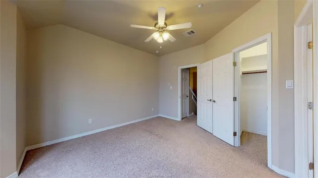 an empty room and chandelier fan