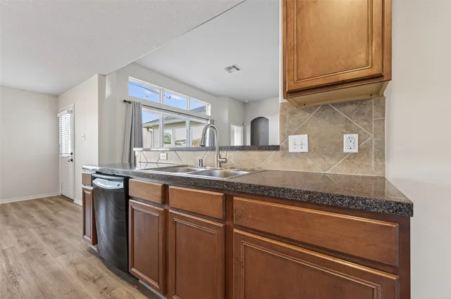 a kitchen with granite countertop stainless steel appliances a sink and cabinets
