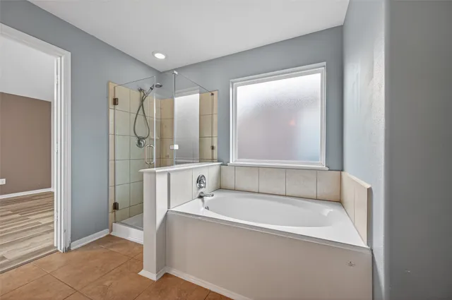 a bathroom with a tub shower and sink