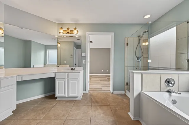 a spacious bathroom with a bathtub sink and a mirror