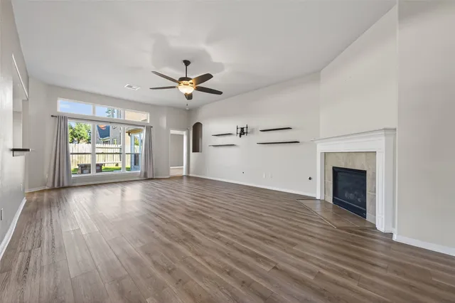 an empty room with windows and fireplace