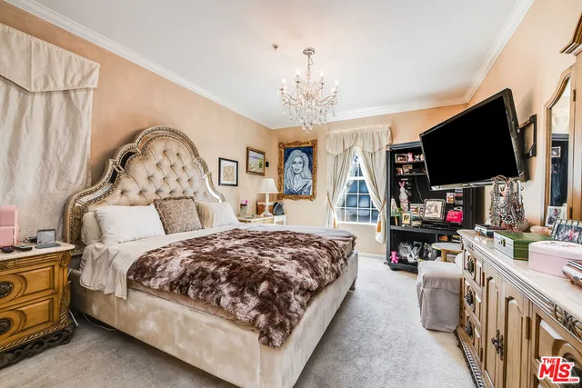 a spacious bedroom with a bed a couch and a flat screen tv